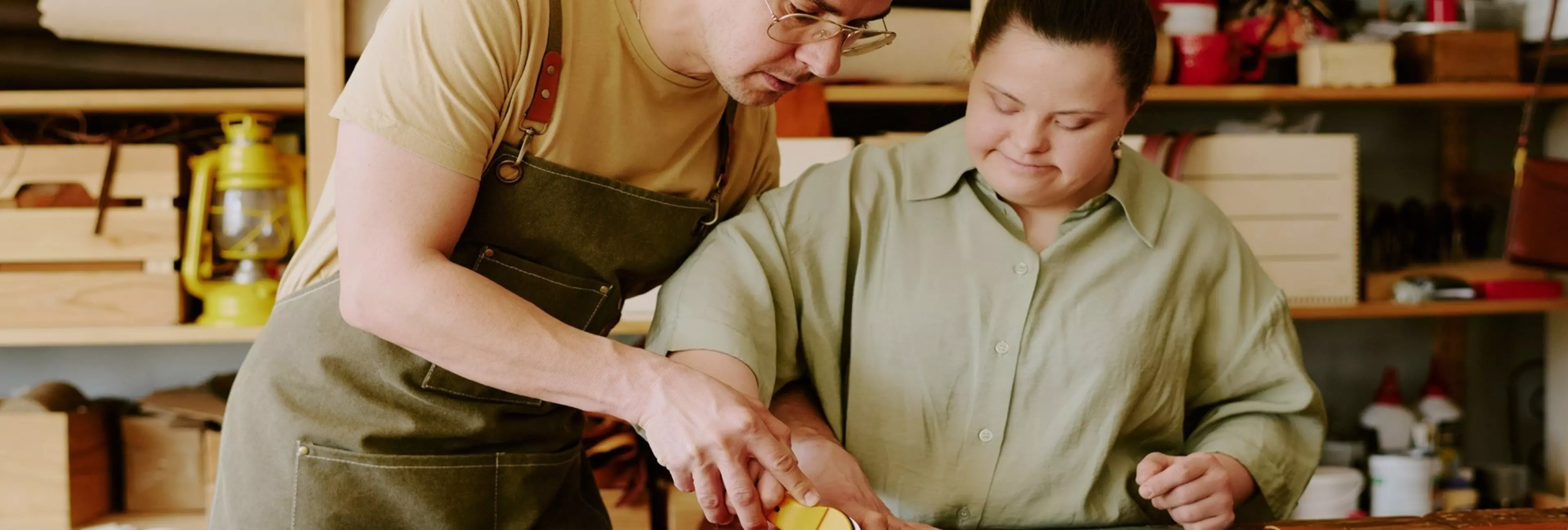 Male tailor helping his female coworker with down syndrome to cut out leather detail while they working in atelier together
Atelier Workers Helping Each Other
tailor, togetherness, help, cut out, leather, workpiece, atelier, handmade, assistance, fabric, inclusivity, material, textile, natural, table, desk, sew, tool, intern, colleague, teamwork, cooperation, communication, interaction, workshop, craftshop, craftsmanship, garment, manufactory, production, down syndrome, diversity, disability, woman, man, work, job, business, hobby, process, creation, customized