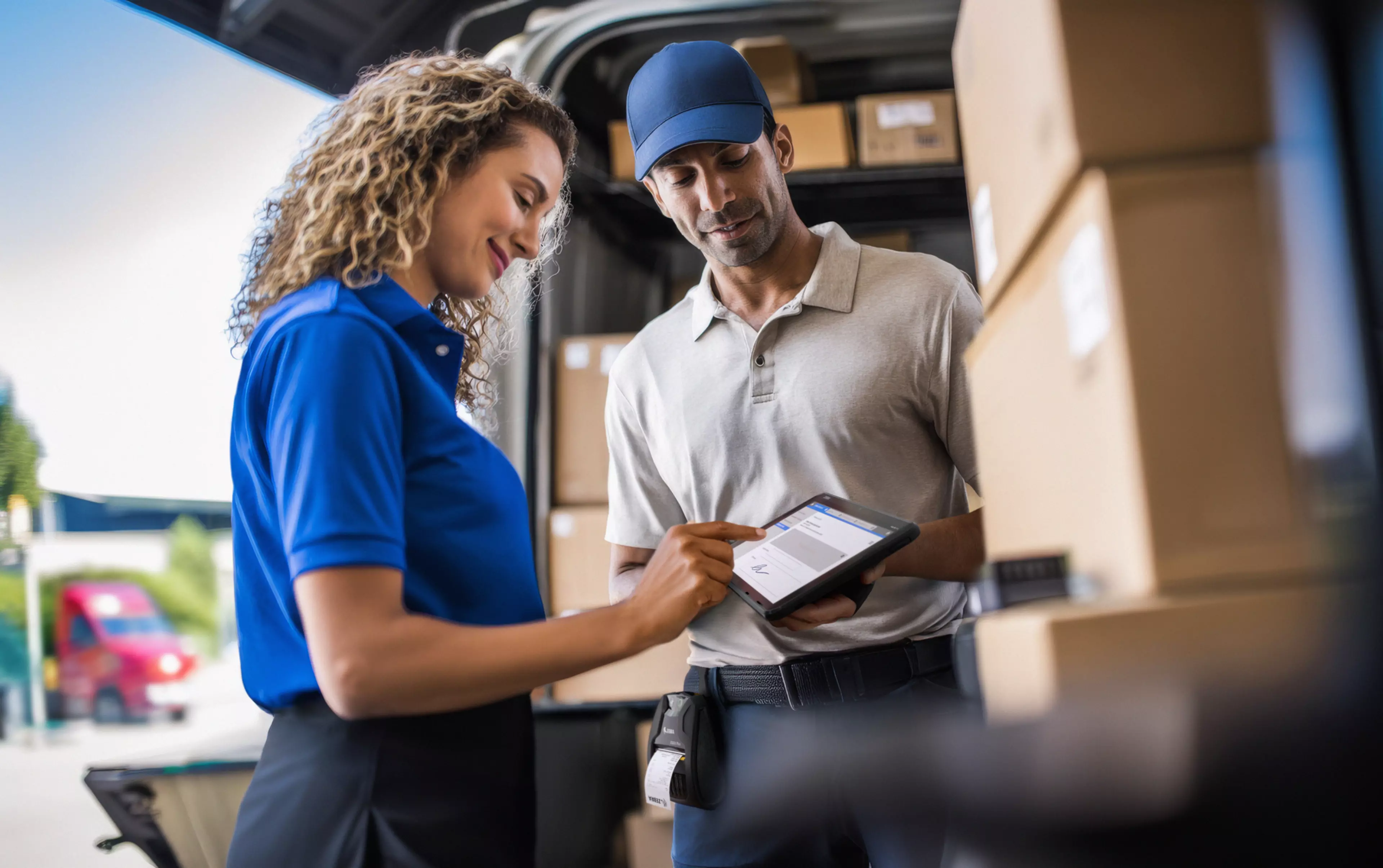 editorial-style scene outside a retail store near the loading zone. A delivery worker in light grey polo shirt, navy pants, black shoes, and a cap stands full-body, holding an 8-inch rugged tablet in landscape orientation with an expansion back hand strap. The customer, wearing a blue polo shirt and dark pants, is also fully visible from head to toe, holding a stylus or finger to sign on the tablet screen. A Zebra ZQ320 Plus mobile printer (black) is clipped to the delivery workerâ€™s belt. Several cardboard boxes are stacked on a nearby dolly to complete the delivery context. The tablet screen is clearly visible, showing a digital signature interface. Lighting is neutral white daylight (5000K) with soft side illumination, natural skin tones, visible pores, realistic hands with fine textures and proper anatomical proportions. Clothing and accessories show fabric folds and specular highlights. Use a wide-angle lens, pulled back slightly, capturing the full-body interaction. Include a foreground blur element (such as a box or dolly handle), and maintain deep depth of field: sharp focus on main subjects, softly blurred background loading zone. Horizontal 16:9 composition, UHD 8K resolution, ultra-detailed --ar 43:27 --stylize 50 --v 7 Job ID: b03de556-0f62-439d-a8ff-a0d40f4f28fd
transportation-logistics-photography-application-et401-zq320-plus-signature-capture-proof-of-delivery-6000x3768-pix-300-dpi
transportation, logistics, tablet, et401, zq320, plus, signature, capture, proof, of, delivery, 3d render, integration, ai