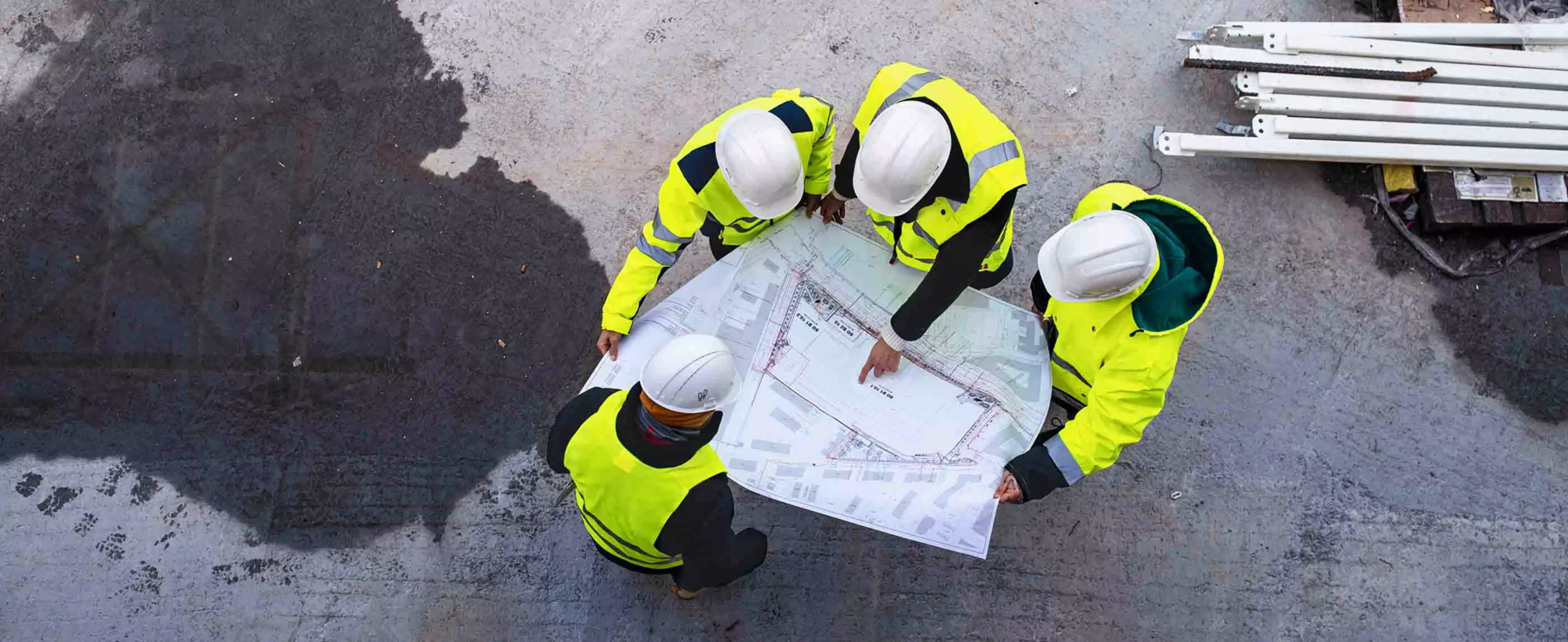 Cuatro trabajadores de la construcción mirando unos planos