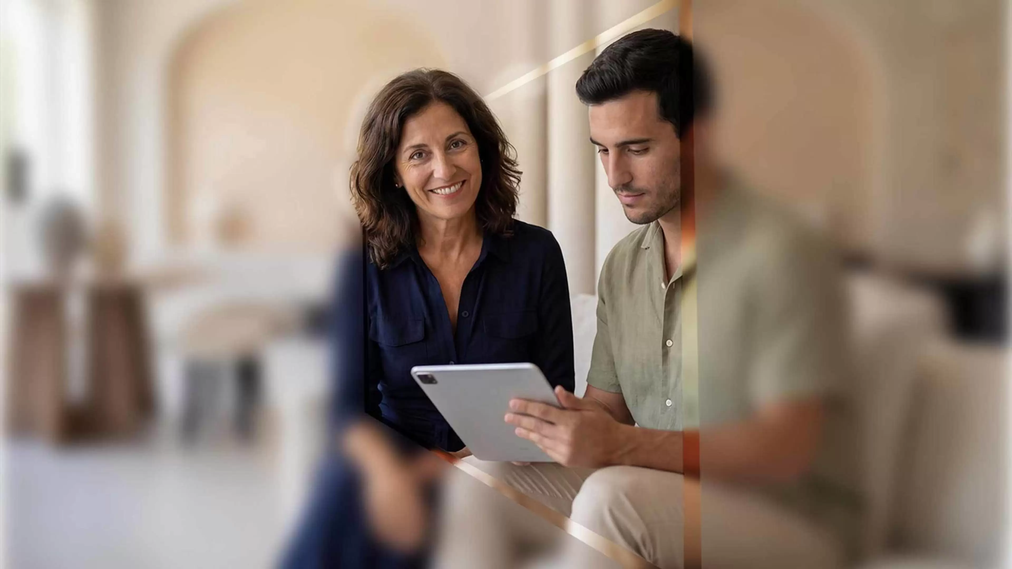 Dos personas en una oficina consultan una tablet.