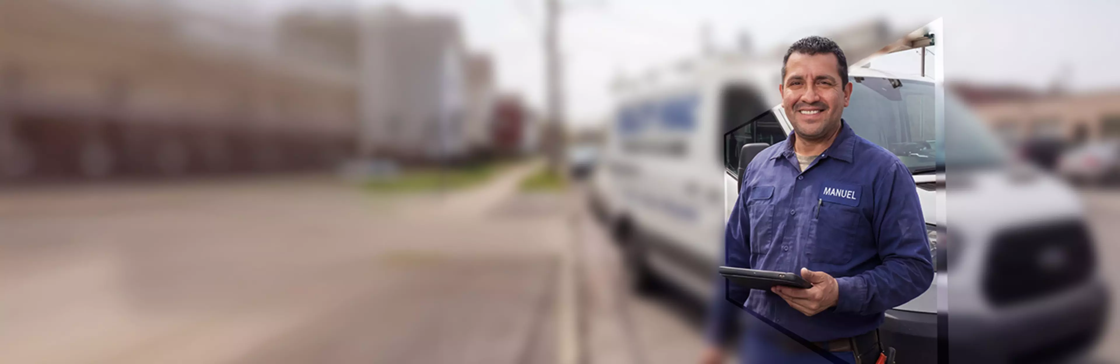 Medarbeider med nettbrett foran servicebil som illustrerer mobil tilgang til informasjon og digitale arbeidsprosesser.