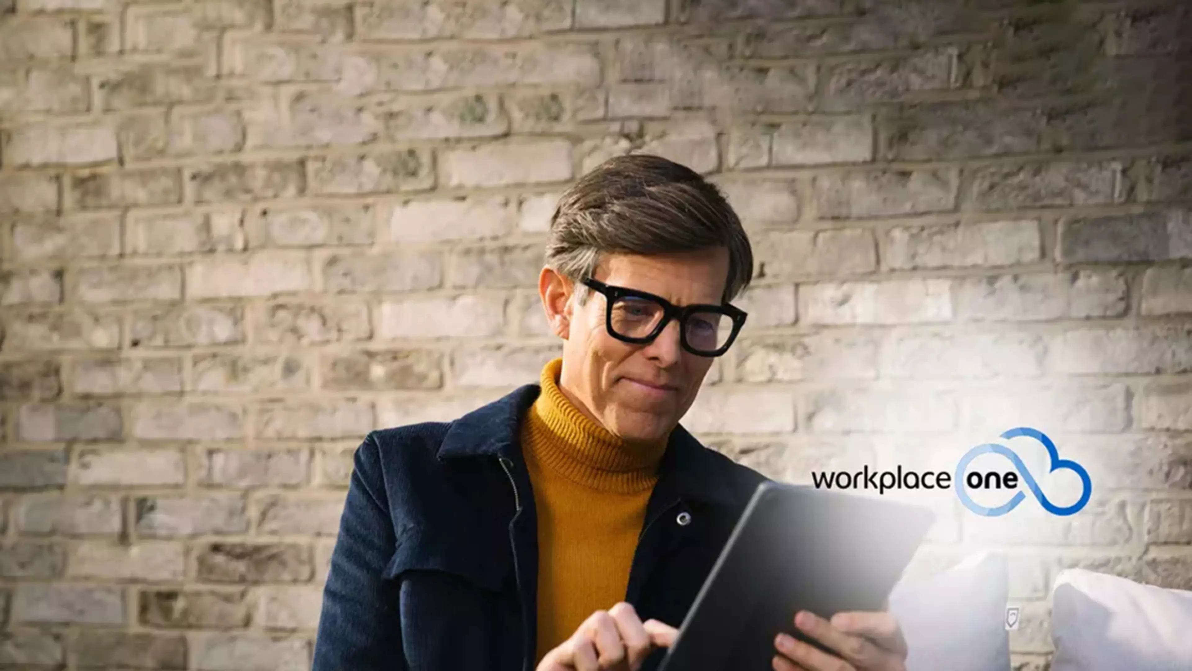 Trabajador en la oficina con un tablet y logo de Workplace One