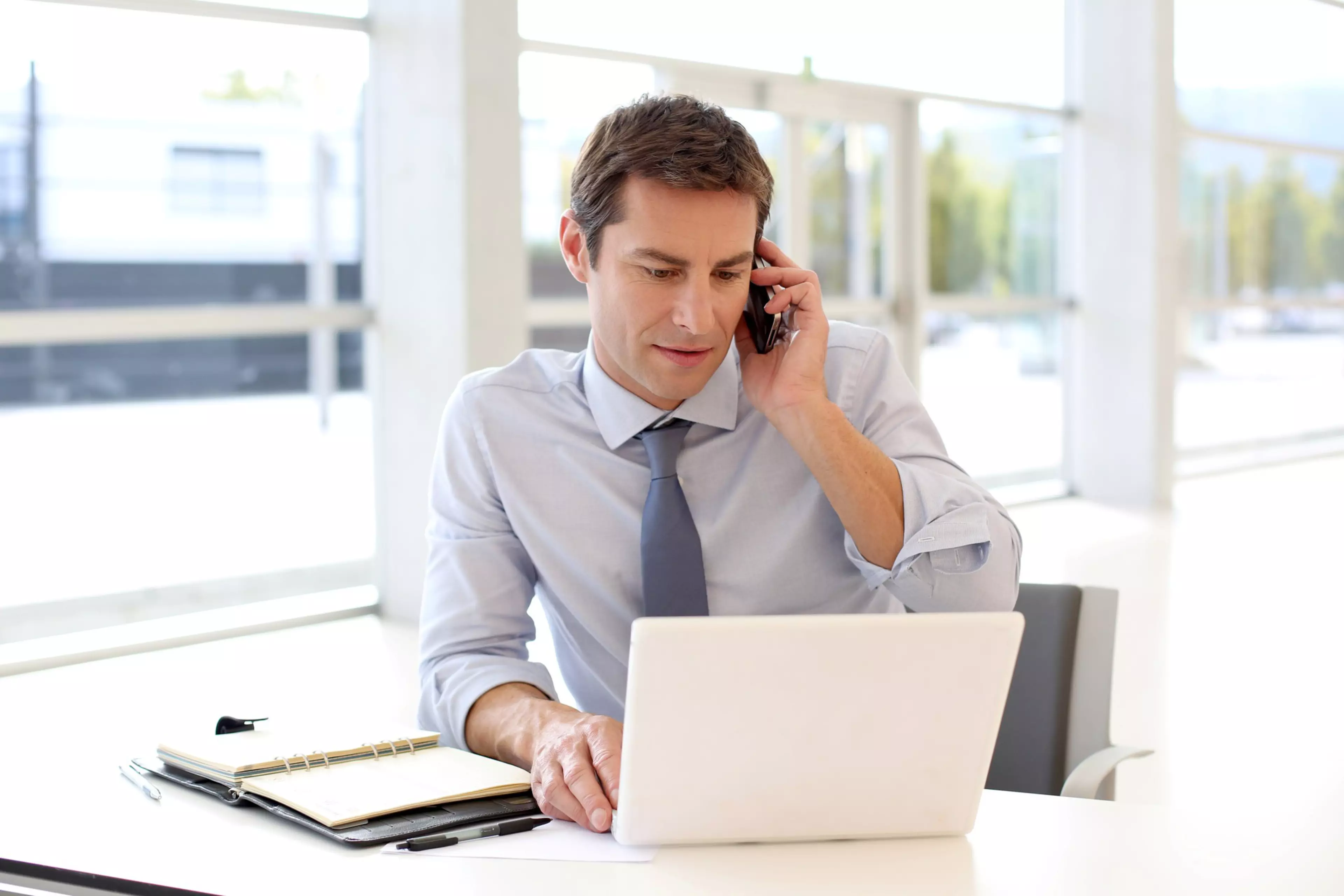 Portrait of businessman talking on mobile phone in office; Shutterstock ID 115790488
adult,  business,  businessman,  casual,  caucasian,  computer,  conversation,  corporate,  desk,  employee,  european,  forties,  handsome,  happy,  indoors,  job,  laptop,  man,  occupation,  office,  phonecall,  portrait,  professional,  salesman,  satisfaction,  satisfied,  sitting,  smile,  talking,  telephone,  looking at camera,  mobile phone,  office worker