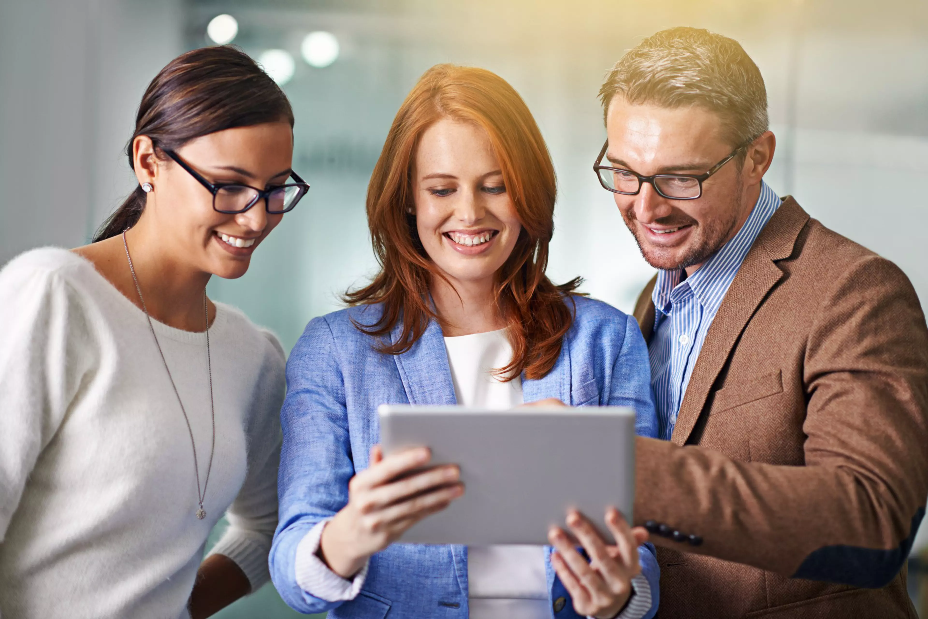 Kolme työntekijää työskentelevät yhdessä tabletilla pilviympäristössä