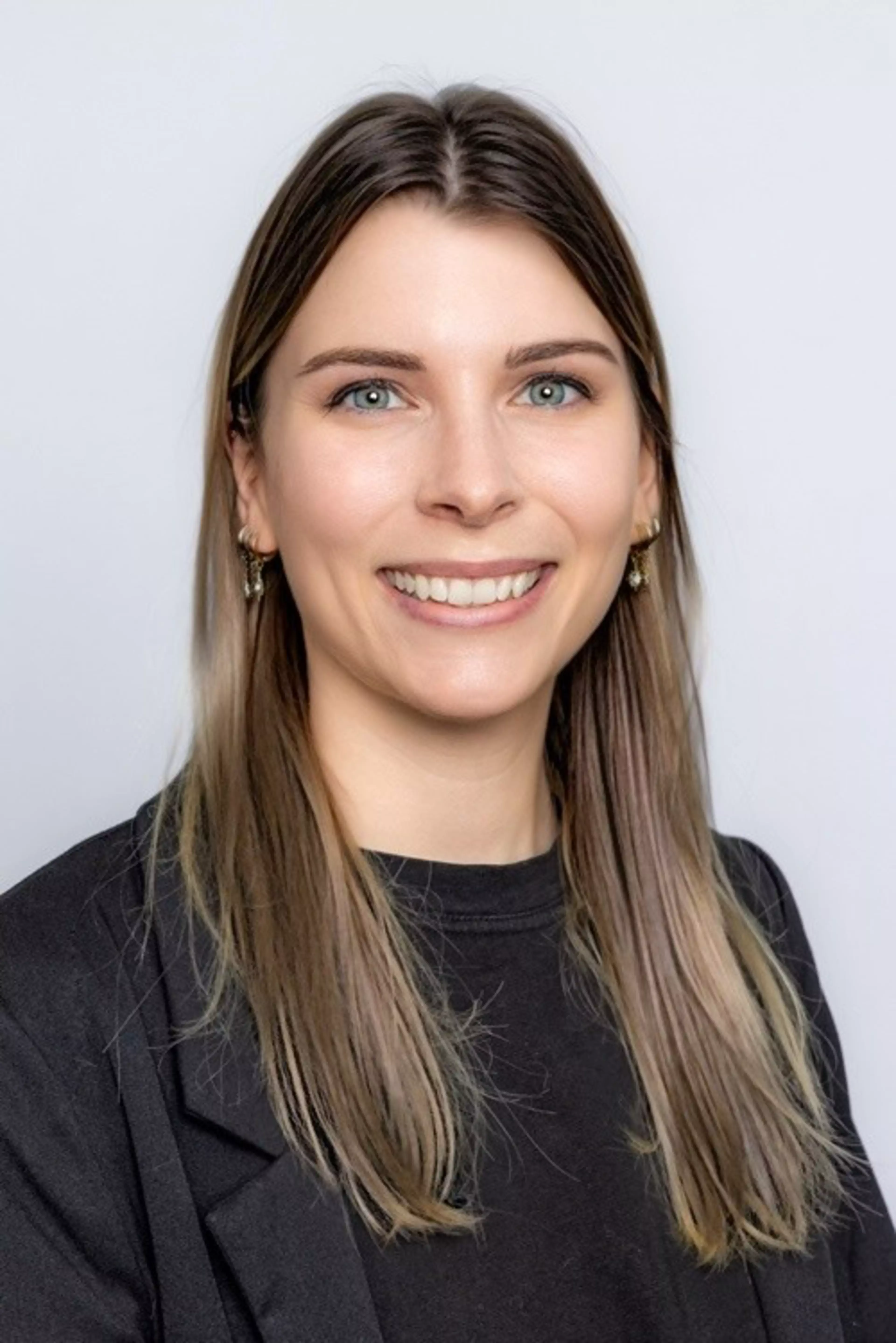 Kathrin Lemberger, Marketing Automation Manager bei Konica Minolta, im Porträt – mit langen Haaren, schwarzem Blazer und hellem Hintergrund.