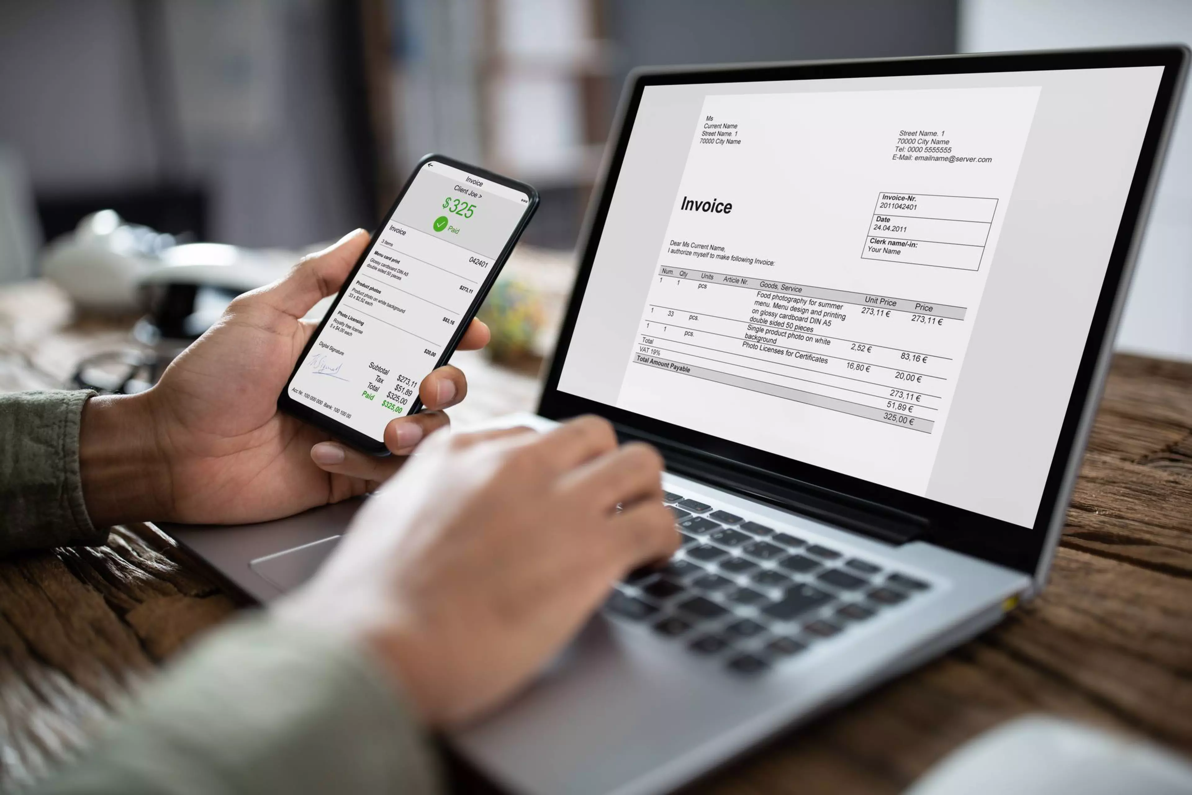 Close-up Of Businessman's Hands Working On Invoice On Laptop At Office