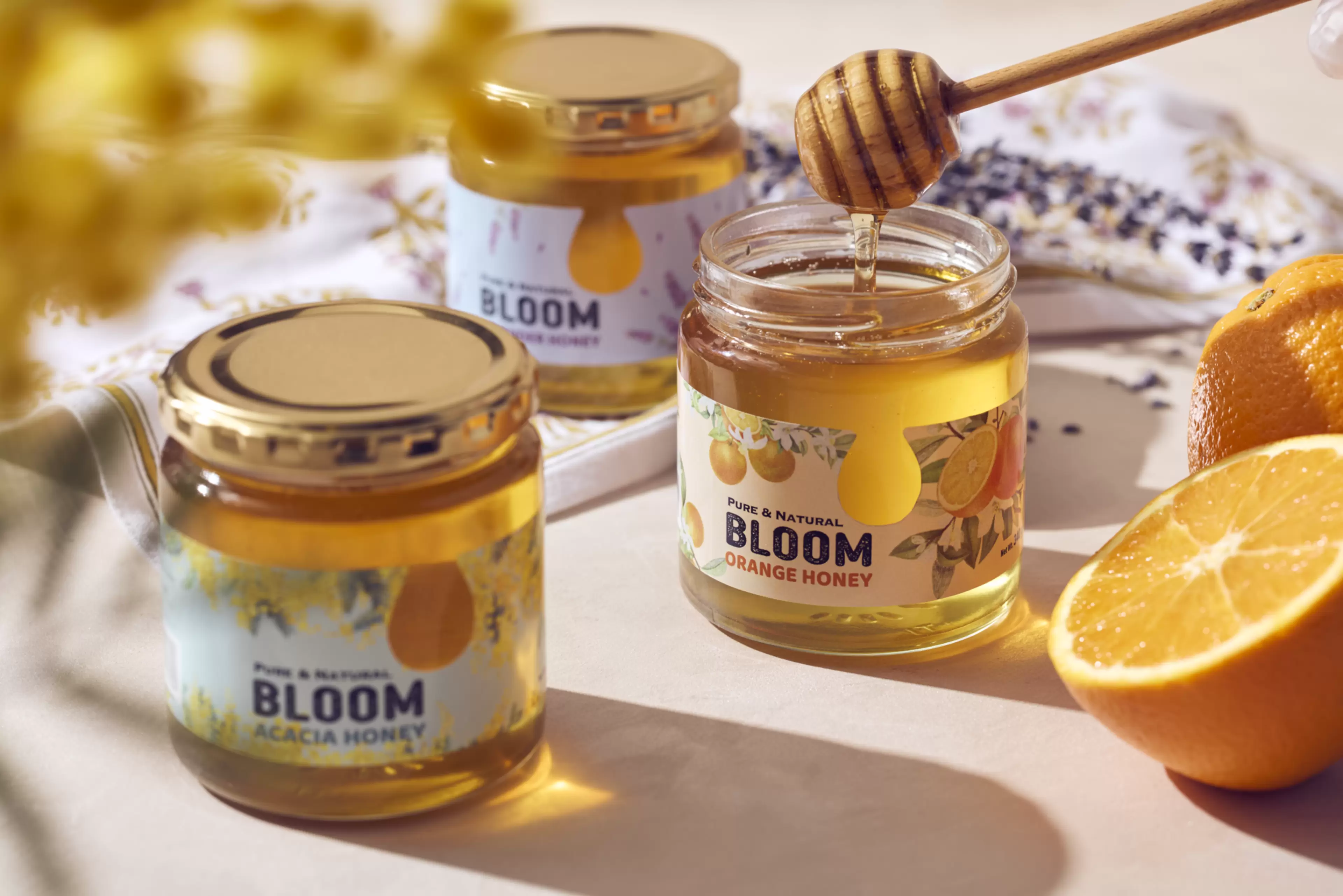 Natural honey jars filled with golden honey, fresh orange slices, and a honey dipper.