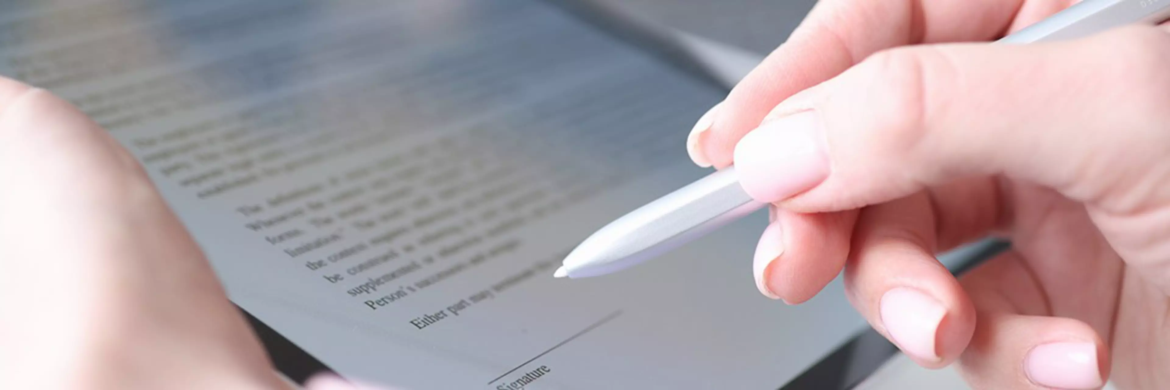 Woman hand holds stylus and puts an electronic signature in contract on tablet