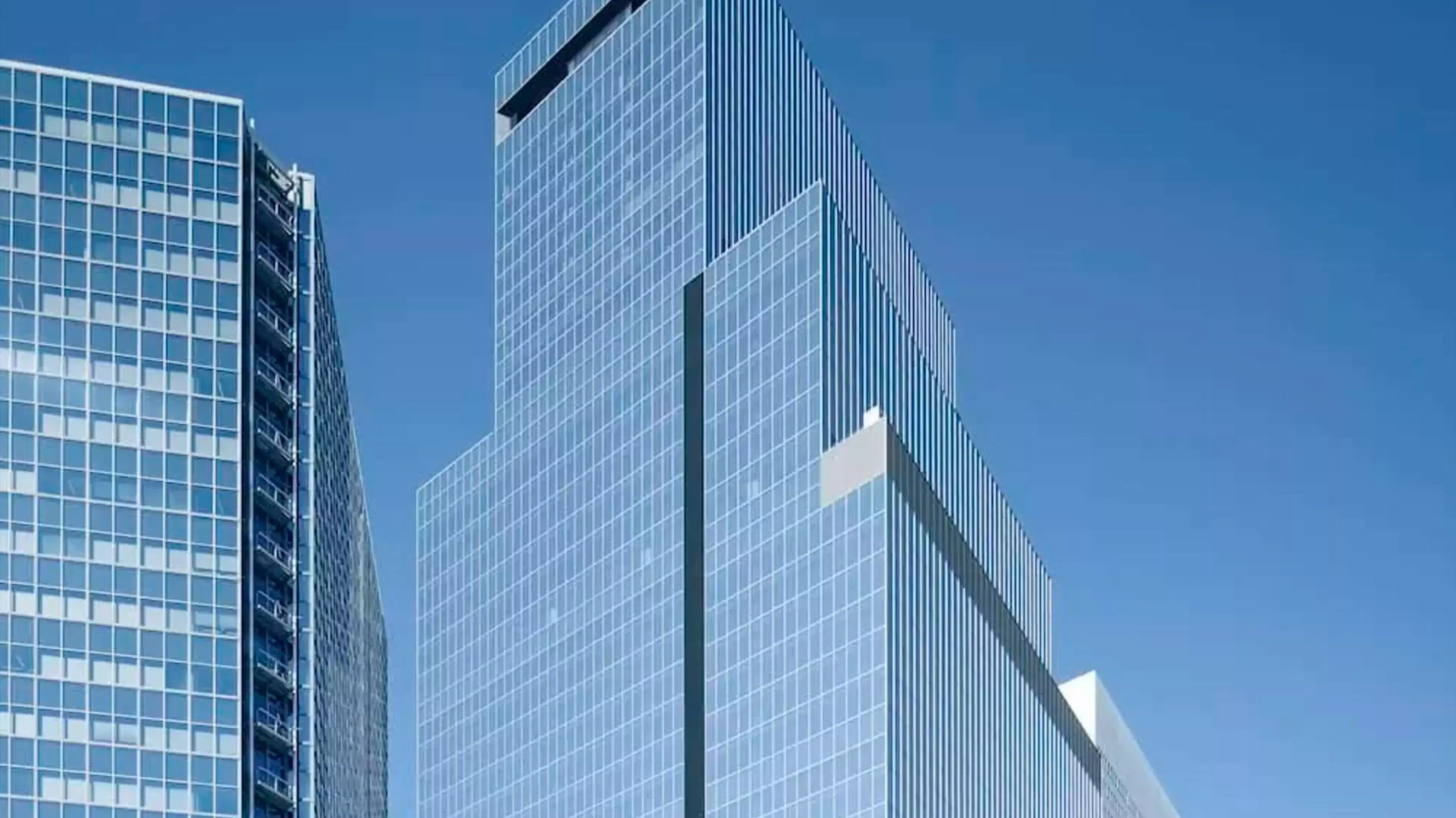 Edificio de la sede de Konica Minolta en Japón. Es un rascacielos moderno que se recorta contra el cielo azul.