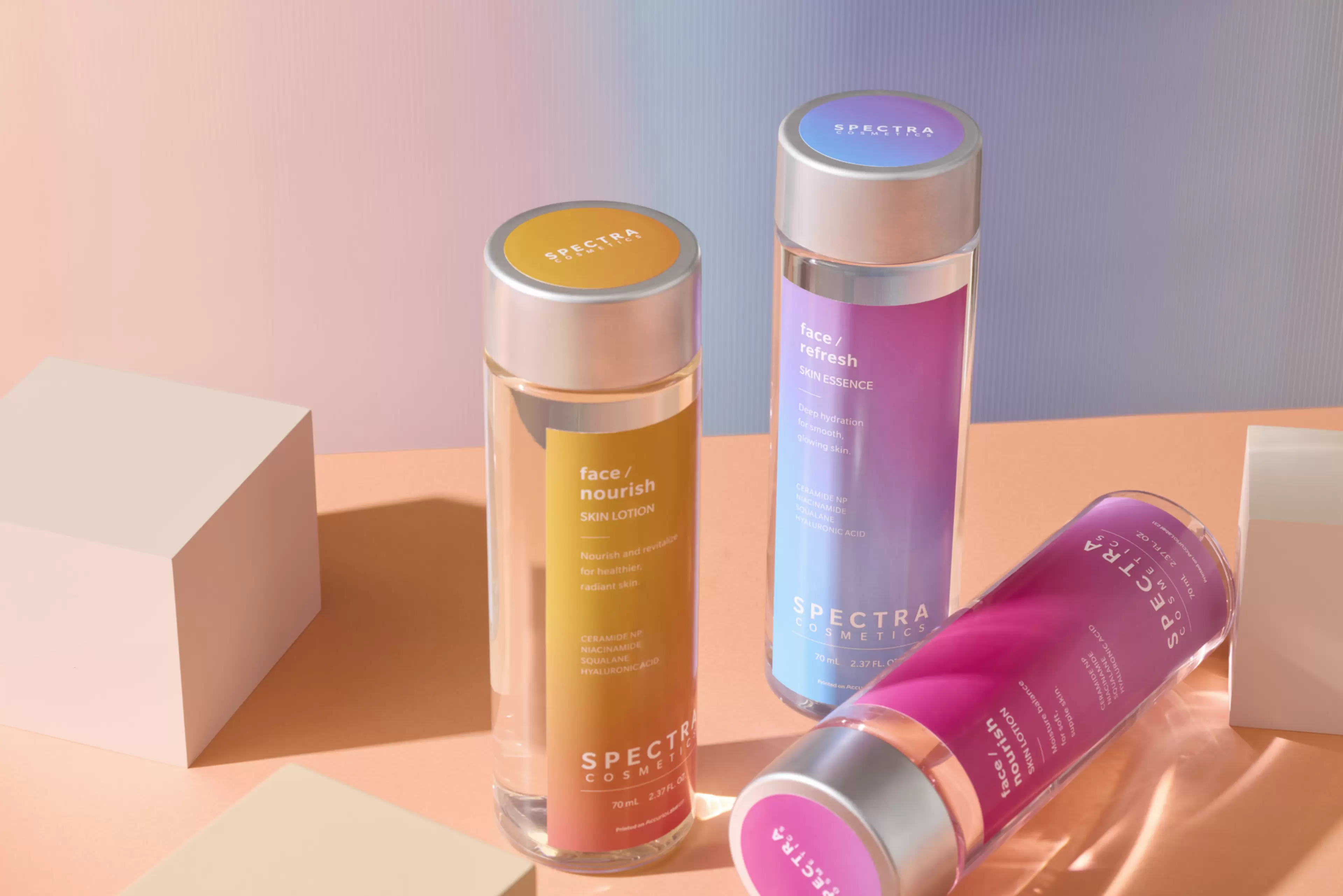 Colorful cosmetic bottles in vibrant pink, purple, and yellow packaging displayed against a modern pastel background.