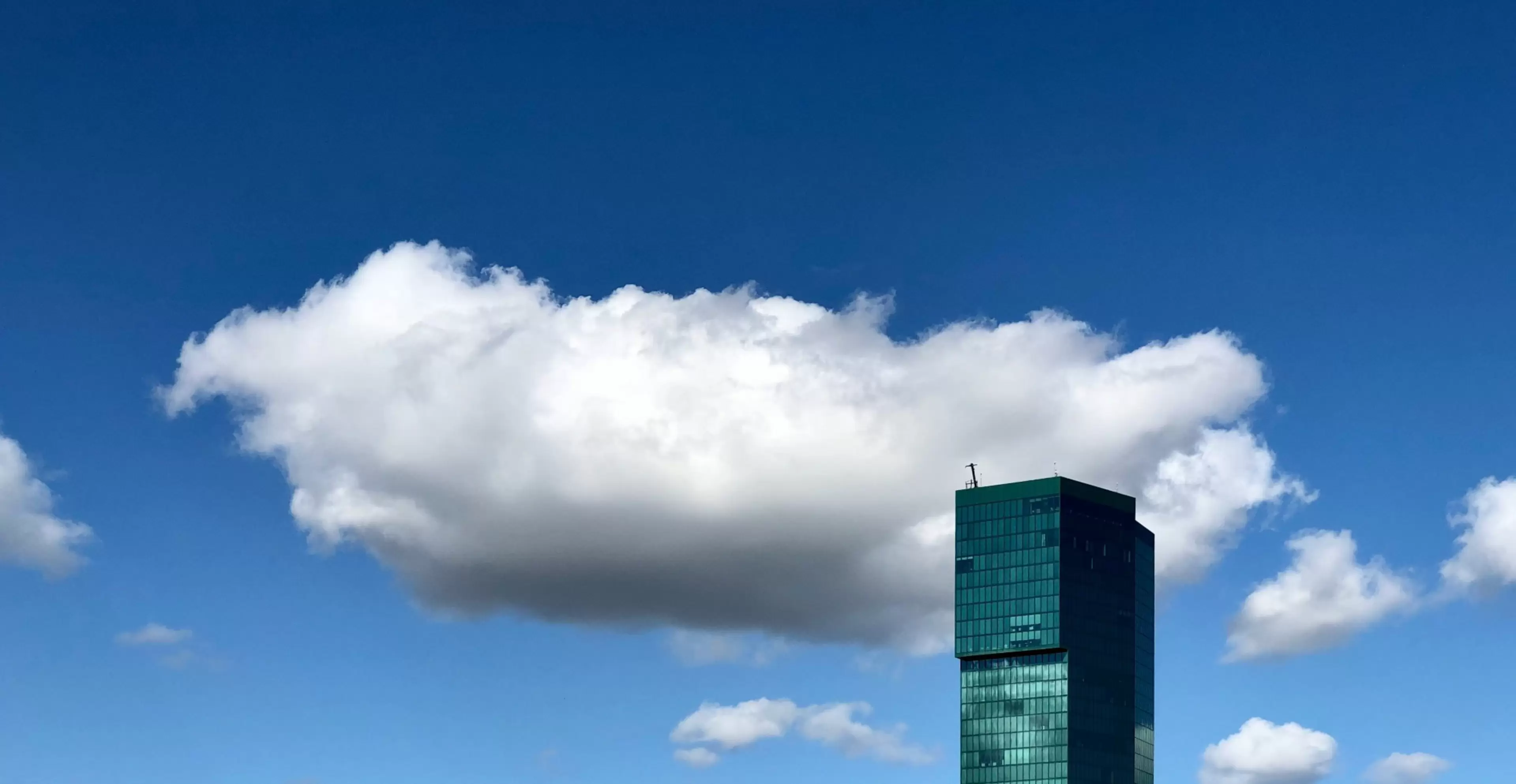 Un rascacielos corporativo se eleva entre las nubes.