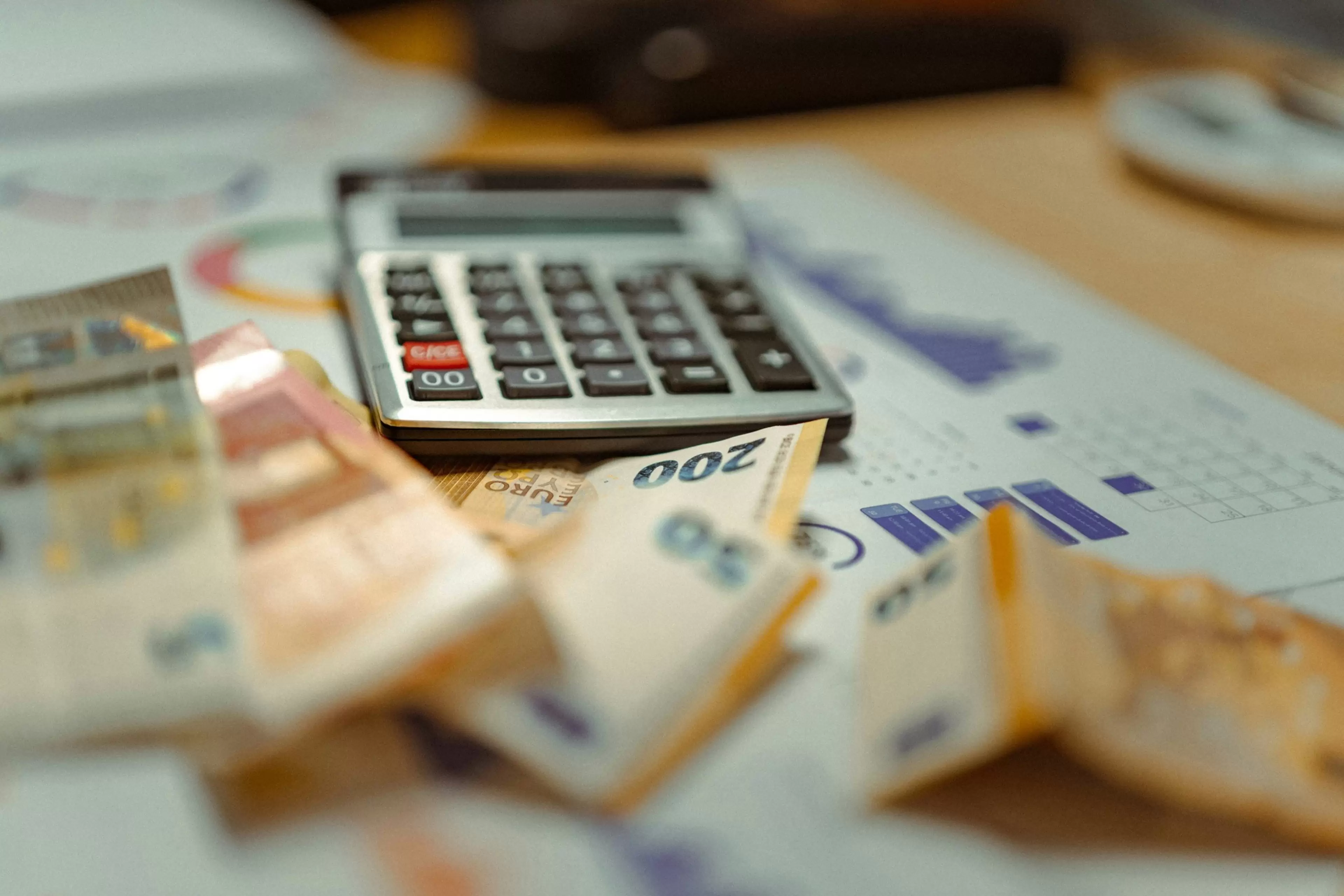 Calculadora y billetes bancarios sobre documentos con gráficos