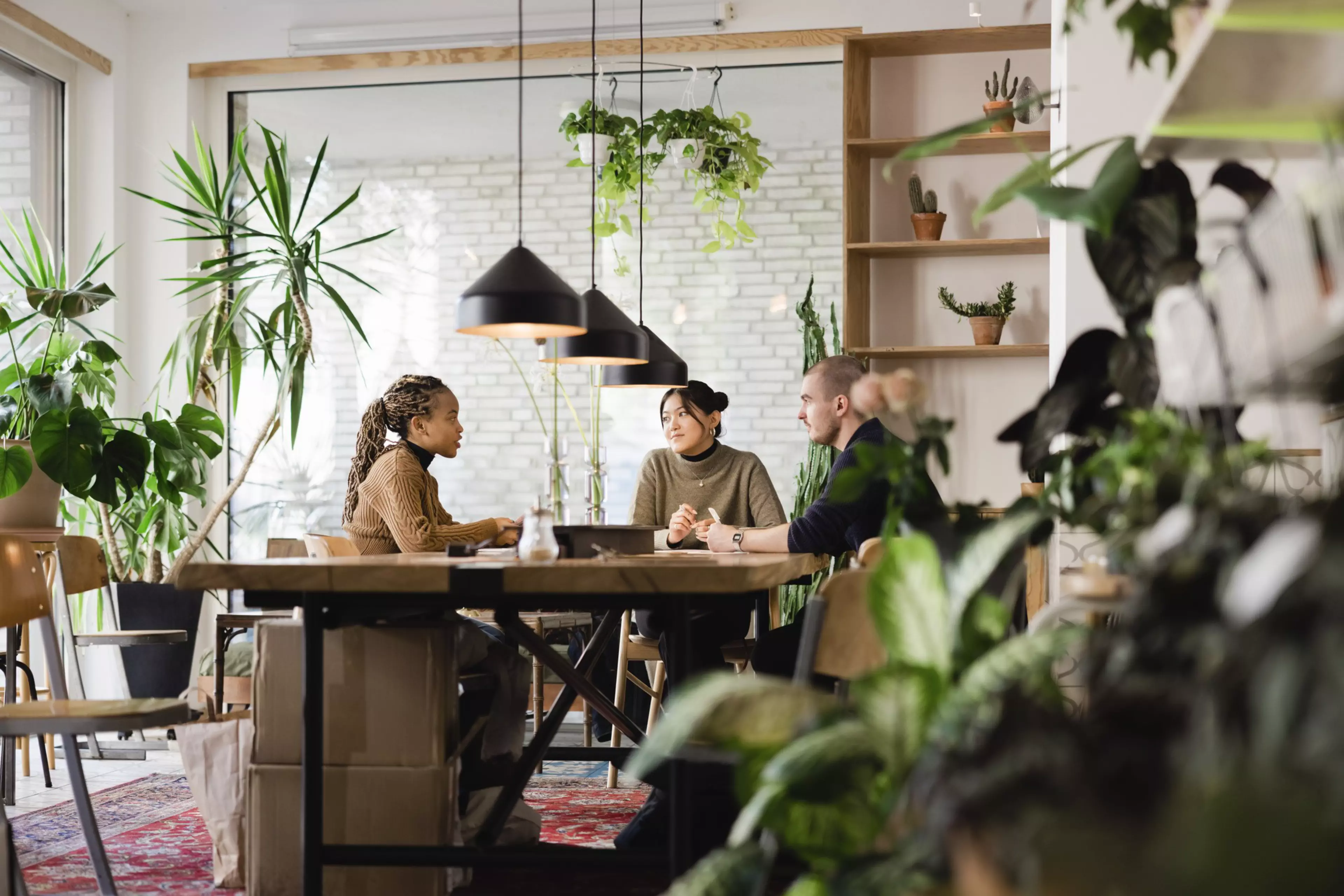 Dos personas entrevistando a una mujer joven en una sala de reuniones