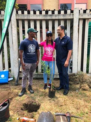 FTFA representatives Jeminah Mkhize and Teboho Mosehle with Craig Williams, national technical & training manager at Konica Minolta SA, showing the pupils of AB Xuma School how to plant and care for a tree.
